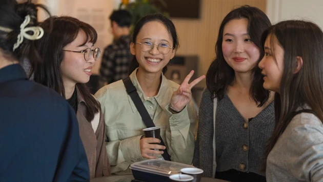 A group of young women standing around a table.